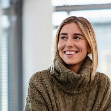 Femme souriante grâce à sa couronne dentaire