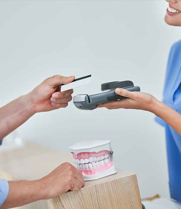 patiente qui règle un dentiste
